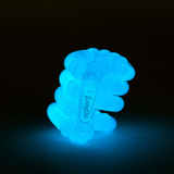 Orange glow-in-the-dark Tangle Jr. bumpy fidget toy glowing warm orange in the dark