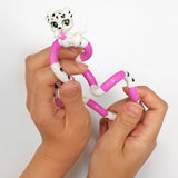 Two hands twisting a pink and white dalmatian Tangle Jr. Pet fidget toy