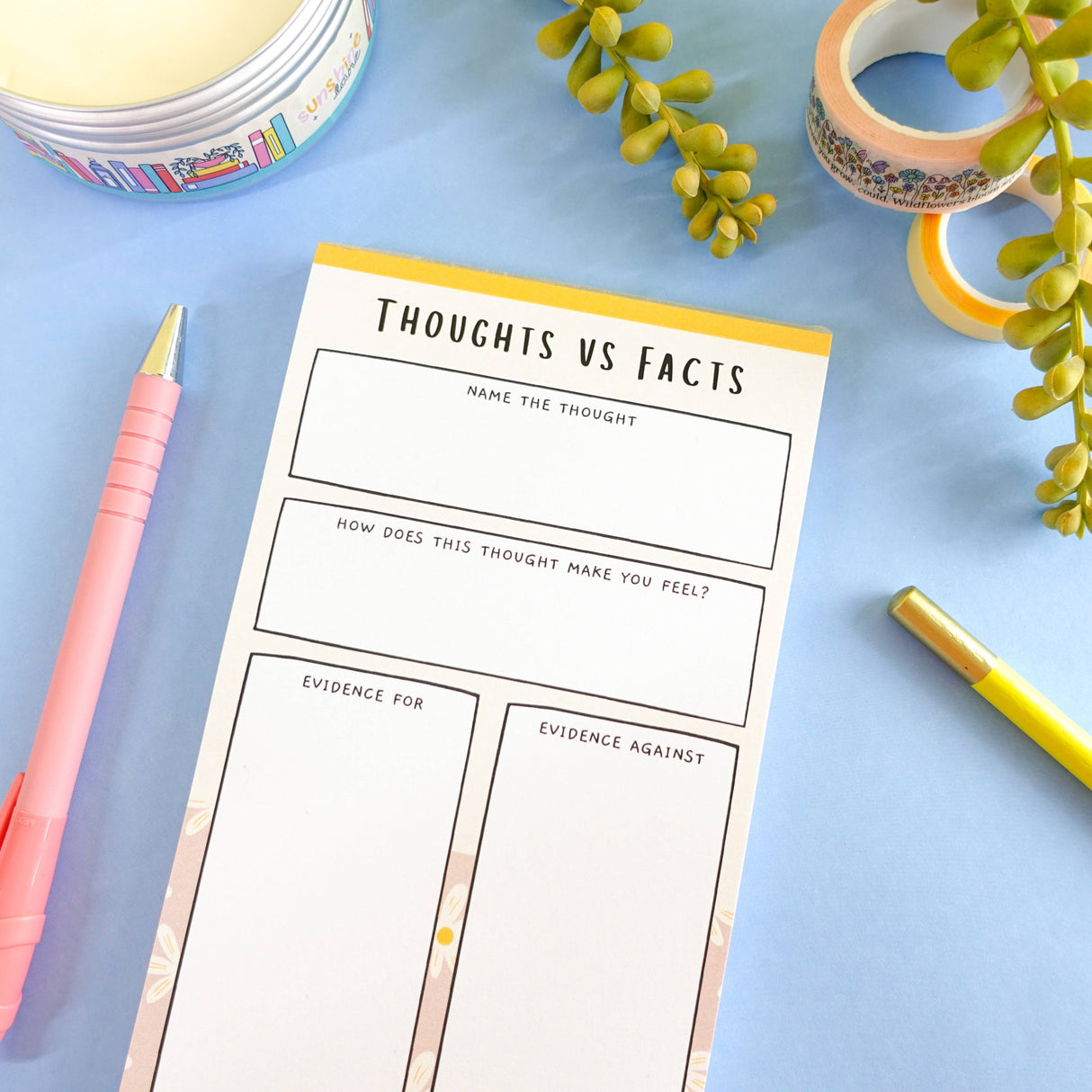 Thoughts vs Facts CBT notepad flat lay on blue, mental health stationery
