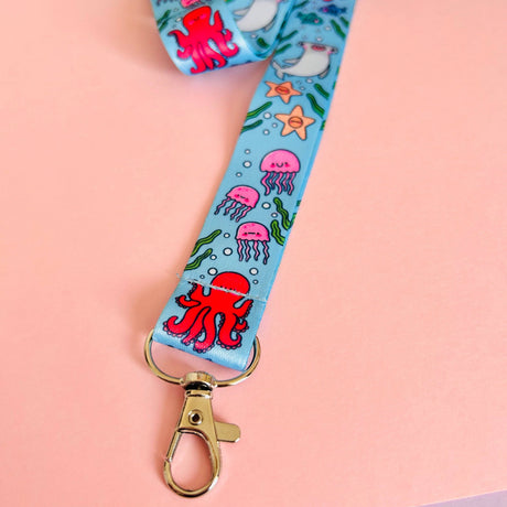 Lanyard with ocean-themed design featuring octopus, jellyfish, and starfish on a pink background