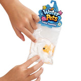 A person's hands holding a clear plastic bag containing a white and orange fish-shaped squishy toy, with a blue 'Water Pets' hanger card at the top, on a white background.