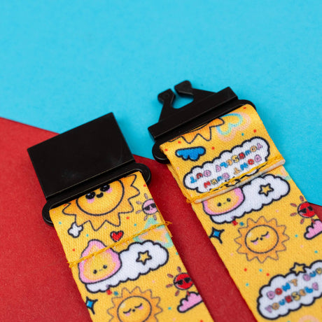 yellow sun lanyard that says "don't burn yourself out," with focus on the black plastic buckle