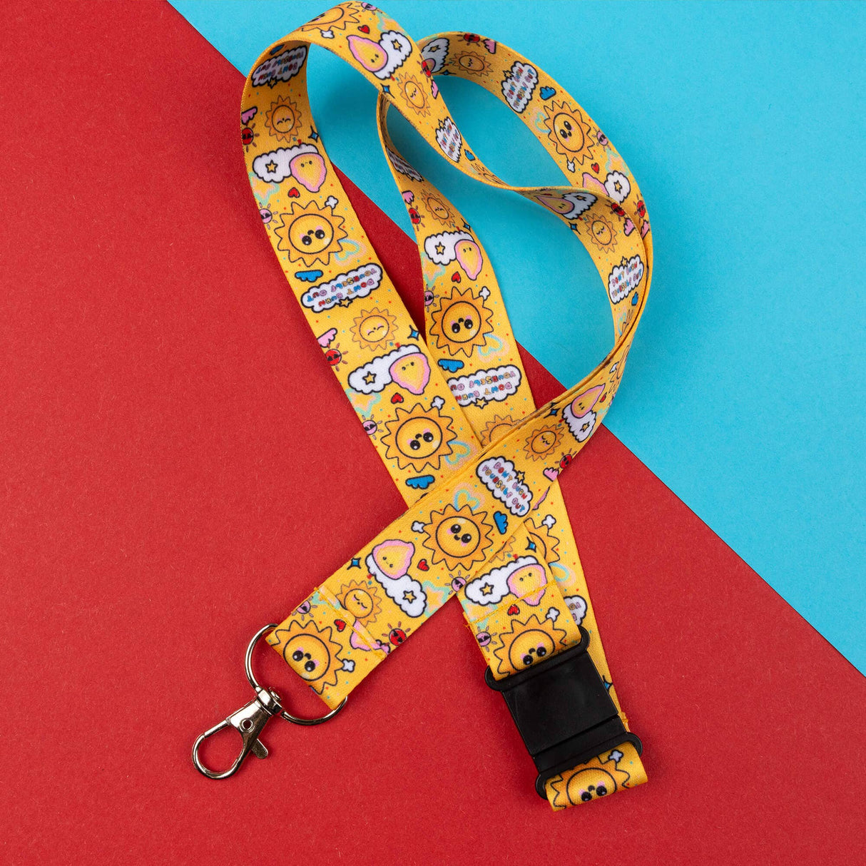 Yellow lanyard with cartoon sun and cloud design on a red and blue background