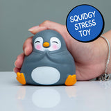 Hand gently squeezing the top of the Zen-Guin kawaii penguin squishy on a flat surface