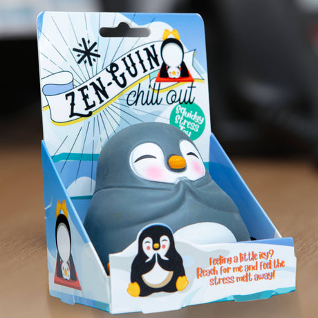 Kawaii penguin squishy stress toy in its blue Zen-Guin Chill Out gift box on a desk